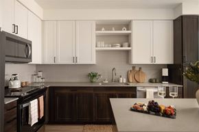 Phoenix apartment for rent - A kitchen with white cabinets and a wooden island.