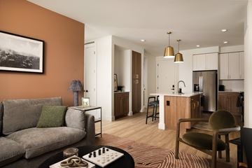 Phoenix apartment for rent - A living room with a grey couch and a coffee table with a chess board on it.