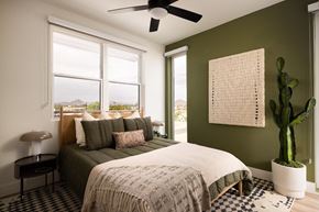 Phoenix apartment for rent - A bedroom with a bed, a cactus, and a fan.