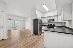 Gillette apartment for rent - A kitchen with white cabinets and a black refrigerator.