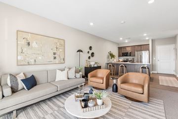South Sioux City apartment for rent - A living room with a grey couch, a coffee table, and a large painting on the wall.
