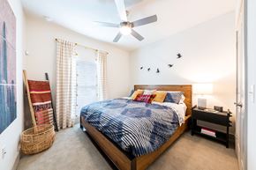 Austin apartment for rent - Lenox SoCo Apartments  bedroom with a bed and a ceiling fan