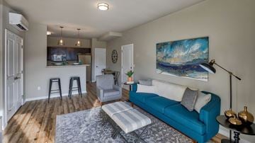 Airway Heights apartment for rent - A living room with a blue couch and a painting on the wall.