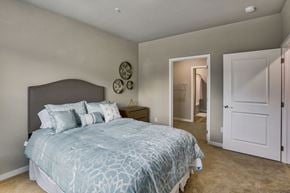 Airway Heights apartment for rent - A bedroom with a large bed and a mirror on the wall.