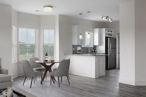 Olathe apartment for rent - A modern kitchen with a dining table and chairs.