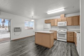 Spokane Valley apartment for rent - A kitchen with wooden cabinets and a white stove top oven.