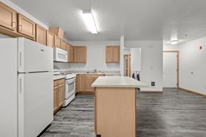 Spokane Valley apartment for rent - A kitchen with white appliances and wooden cabinets.