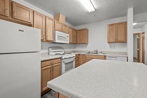 Spokane Valley apartment for rent - A kitchen with white appliances and wooden cabinets.