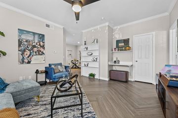 Euless apartment for rent - A living room with a blue couch and a painting on the wall.