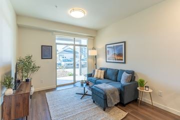 Kalispell apartment for rent - a living room with a blue couch and a sliding glass door