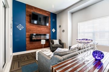Everett apartment for rent - A modern living room with a grey couch and a wooden wall.