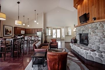Tualatin apartment for rent - A living room with a stone fireplace and a dining table with chairs.