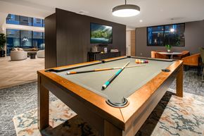 Shoreline apartment for rent - A pool table in a room with a television and a couch.
