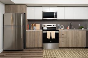 Shoreline apartment for rent - A modern kitchen with a stainless steel refrigerator and wooden cabinets.