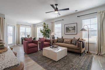 Wilson apartment for rent - A living room with a red chair and a brown couch.