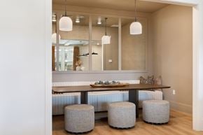 Wilson apartment for rent - A dining area with a long table and grey ottoman.