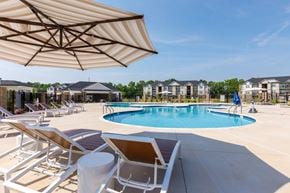 Wilson apartment for rent - A sunny day at the pool with chairs and umbrellas.