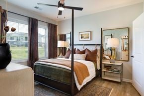 Wilson apartment for rent - A bedroom with a four poster bed and a mirror on the wall.