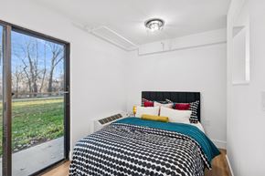 Boise apartment for rent - A bedroom with a bed and a window overlooking a field.