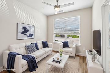 Dallas apartment for rent - A living room with a white couch and a ceiling fan.