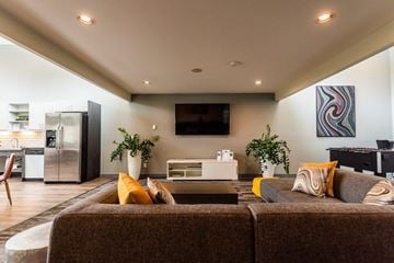 Tacoma apartment for rent - A modern living room with a brown couch and a television on the wall.
