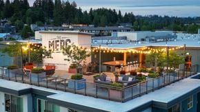 Bothell apartment for rent - The MEDC building is lit up with string lights at dusk.