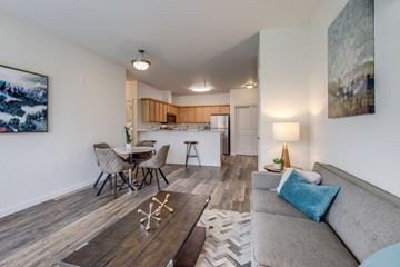 Coeur Dalene apartment for rent - A living room with a grey couch and a wooden coffee table.