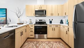 Seattle apartment for rent - A kitchen with wooden cabinets and a black refrigerator.