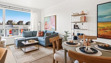 Seattle apartment for rent - A living room with a blue couch, a coffee table, and a painting on the wall.