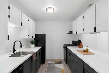 Vancouver apartment for rent - A kitchen with black cabinets and white countertops.