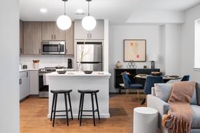 Hyattsville apartment for rent - A modern kitchen with a bar area and a dining table set up.