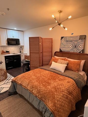 Walla Walla apartment for rent - A bedroom with a bed, a chair, and a kitchen area.