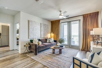 Lewisville apartment for rent - A living room with a brown couch and a rug.