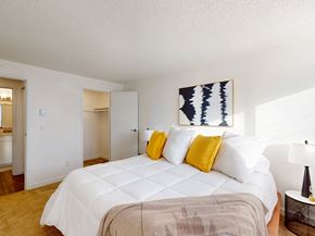 Kennewick apartment for rent - a bedroom with a large white bed and yellow pillows