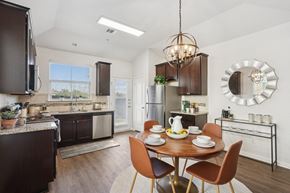 Pflugerville apartment for rent - A modern kitchen with a dining table set for two.