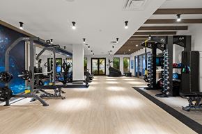 Kirkland apartment for rent - Vela Apartments  spacious fitness center with a large number of exercise equipment and a blue mural on the wall
