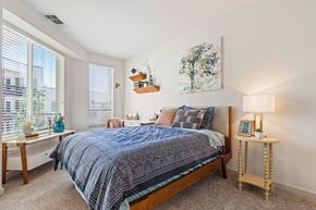 Denver apartment for rent - A bedroom with a bed, nightstand, and a painting on the wall.