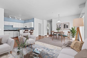 Post Falls apartment for rent - A modern living room with a grey sofa, a glass coffee table, and a dining table with chairs.