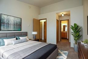 Spokane Valley apartment for rent - a bedroom with a bed and a potted plant