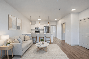 Eugene apartment for rent - A living room with a grey couch, a white coffee table, and a dining table with chairs.