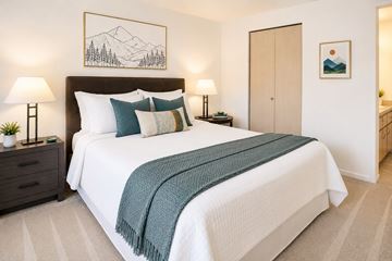 Issaquah apartment for rent - A bedroom with a large bed and a mountain painting on the wall.