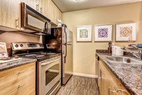 Kirkland apartment for rent - A kitchen with a refrigerator, oven, and sink.
