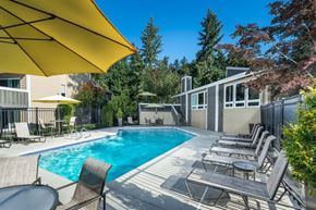 Kirkland apartment for rent - A pool surrounded by chairs and umbrellas.