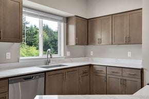 Newport apartment for rent - A kitchen with brown cabinets and a stainless steel dishwasher.