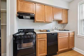 Silver Spring apartment for rent - A kitchen with wooden cabinets and black appliances.