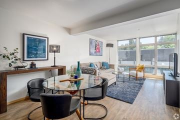Seattle apartment for rent - A modern living room with a glass table and black chairs.