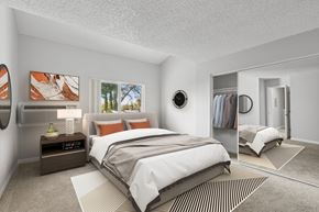 Concord apartment for rent - A bedroom with a large bed, a nightstand with a lamp, and a mirror.