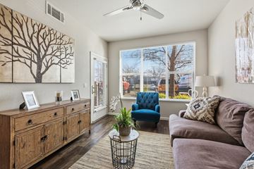 Tracy apartment for rent - A living room with a blue chair and a painting of a tree on the wall.
