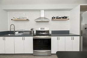 Oakland apartment for rent - a kitchen with white cabinets and a black counter top