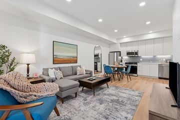 San Diego apartment for rent - A modern living room with a grey couch, a coffee table, and a painting on the wall.